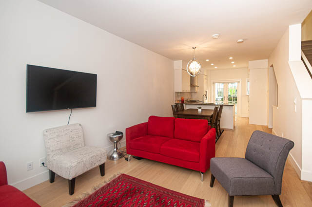 Bright living room with red furniture and hardwood floors. - 9 - 1133 Ridgewood Drive, North Vancouver