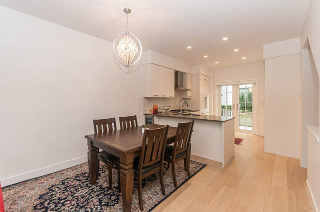 Open-concept dining and kitchen area with hardwood floors and modern chandelier. - 9 - 1133 Ridgewood Drive, North Vancouver
