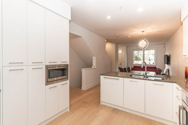 Bright kitchen with white cabinets, hardwood floors, and a city view. - 9 - 1133 Ridgewood Drive, North Vancouver