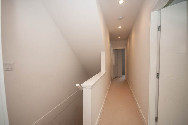 Narrow hallway with white walls and wooden flooring. - 9 - 1133 Ridgewood Drive, North Vancouver