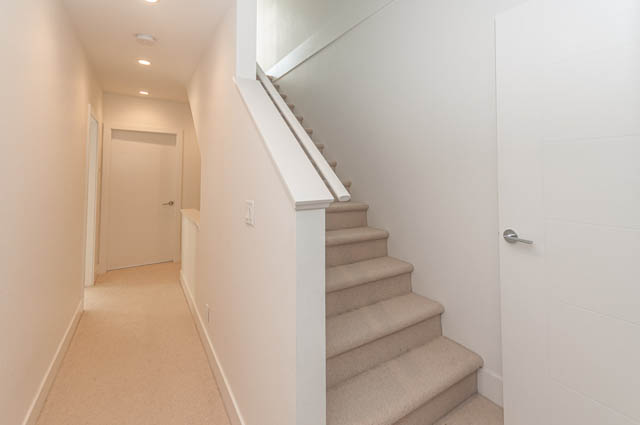 Bright hallway leading to stairs, white walls, carpeted steps. - 9 - 1133 Ridgewood Drive, North Vancouver