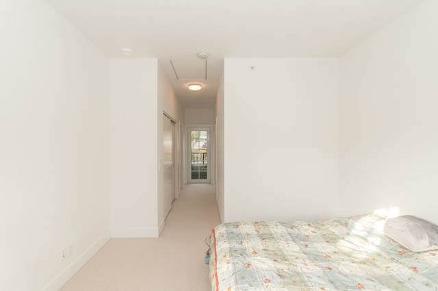 Bright bedroom with light-colored walls and a bed with patterned bedding. - 9 - 1133 Ridgewood Drive, North Vancouver