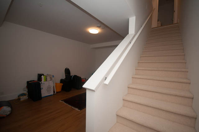Staircase leading to upper level with carpeted steps and white railings. - 9 - 1133 Ridgewood Drive, North Vancouver