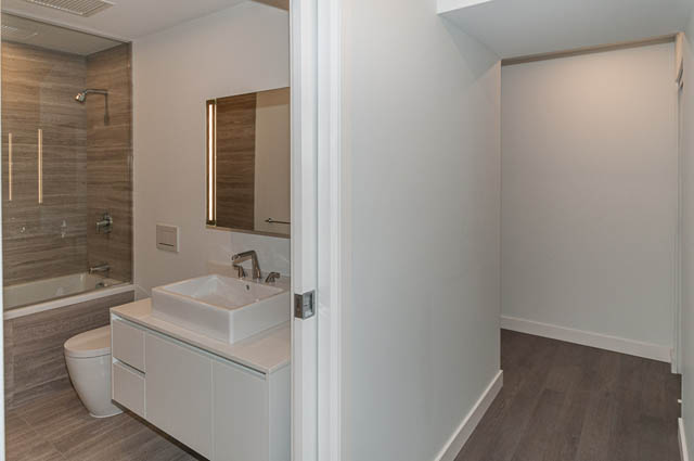 Spacious bathroom with modern sink, wooden vanity, and large mirror. - 807 - 1480 Howe Street, Vancouver Downtown