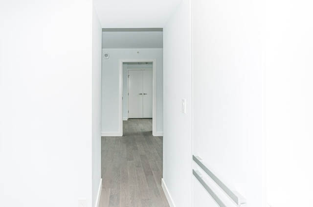 Bright hallway with light wood flooring and white walls leading to another room. - 807 - 1480 Howe Street, Vancouver Downtown