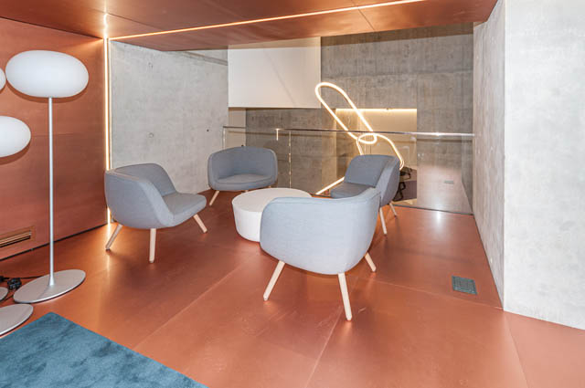 Spacious living room with modern furniture, concrete walls, and warm lighting. - 807 - 1480 Howe Street, Vancouver Downtown