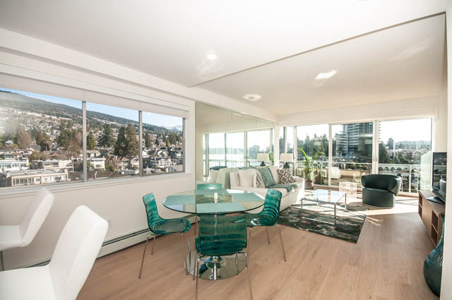 Furnished living room with hardwood floors and a city view. - 708 - 150 24th St, West Vancouver