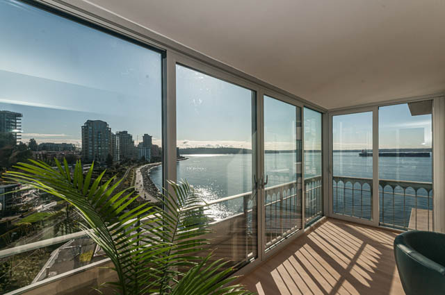 Furnished living room with large windows, city view, and hardwood floors. - 708 - 150 24th St, West Vancouver
