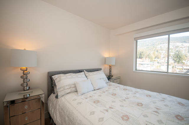 Bright bedroom with city view and modern furnishings. - 708 - 150 24th St, West Vancouver