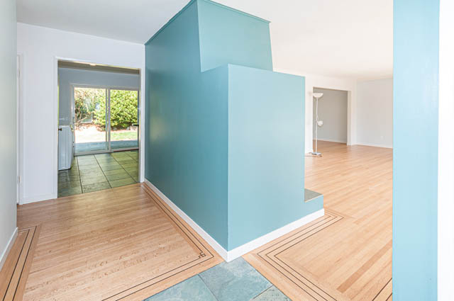 Bright living room with hardwood floors and a sliding glass door leading to a patio. - 4037 Ripple Road, West Vancouver