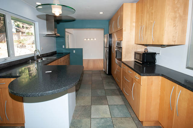 Bright kitchen with granite countertops, hardwood floors, and a city view. - 4037 Ripple Road, West Vancouver