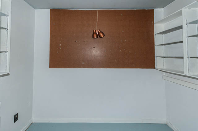 Bright kitchen with white cabinets and a pegboard backsplash, featuring two copper light fixtures. - 4037 Ripple Road, West Vancouver