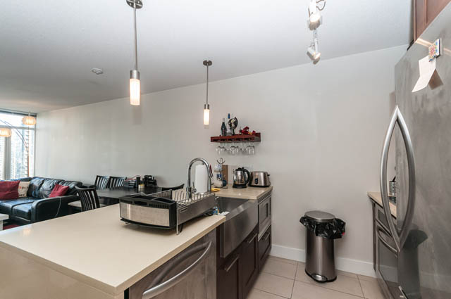 Modern kitchen with white countertops, stainless steel appliances, and a cozy dining area. - 1607 - 888 Homer St, Vancouver Downtown