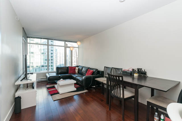 Open-concept living space with hardwood floors, modern furniture, and a city view. - 1607 - 888 Homer St, Vancouver Downtown