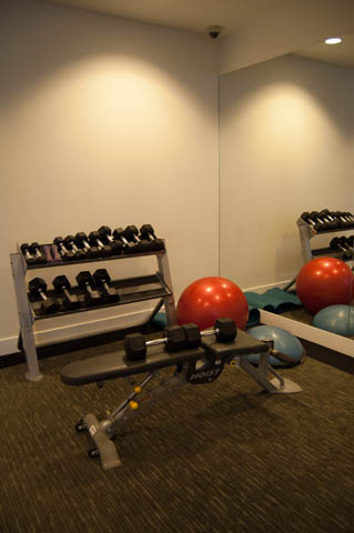 Compact, well-equipped fitness room with dumbbells, exercise balls, and a bench for a 1-bedroom + den condo. - 1607 - 888 Homer St, Vancouver Downtown
