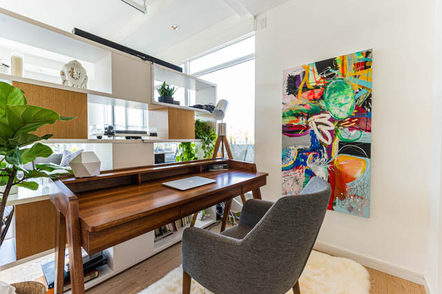 Furnished living room with modern artwork and wooden desk, natural light from large window. - 1101 - 1661 Ontario Street, Vancouver West Side