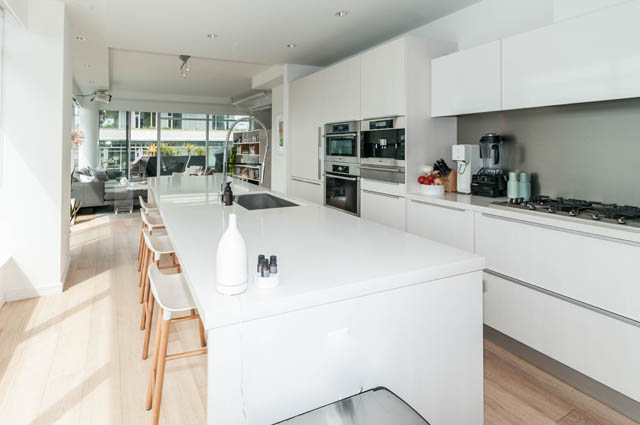 Bright kitchen with white countertops, hardwood floors, and a city view. - 1101 - 1661 Ontario Street, Vancouver West Side