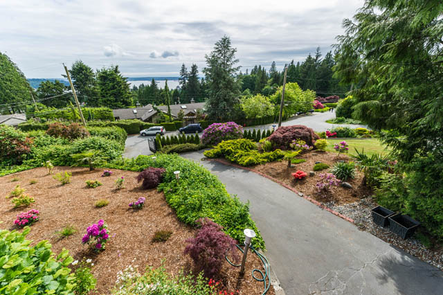 Bright living room with a stunning view of the ocean and lush greenery. - 1249 Nepal Crescent, West Vancouver