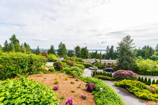 Spacious living room with a stunning city view and lush greenery. - 1249 Nepal Crescent, West Vancouver