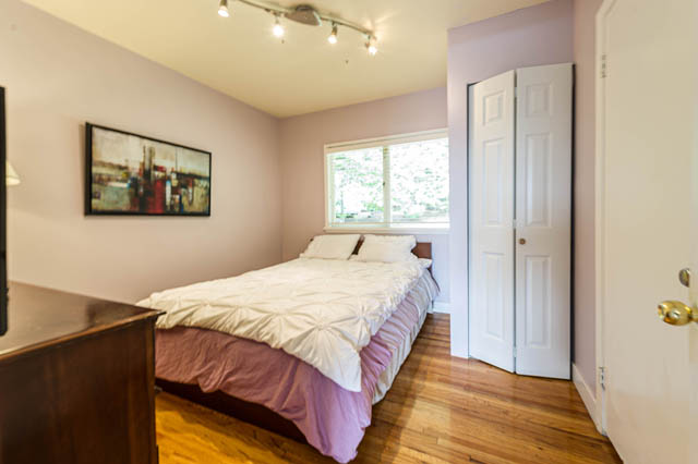 Bright bedroom with hardwood floors and a cityscape painting, showcasing a cozy and modern ambiance. - 1249 Nepal Crescent, West Vancouver