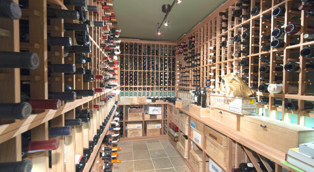 Wine cellar with wooden racks and neatly arranged bottles. - 235 Maple Lane, West Vancouver