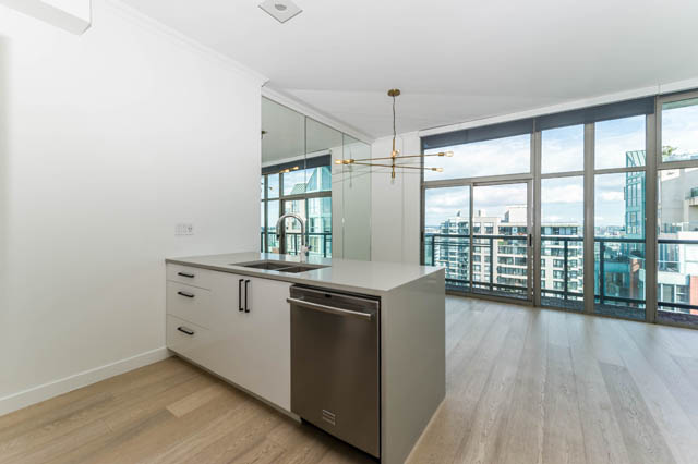 Bright kitchen with white countertops, hardwood floors, and a city view. - 3205 - 928 Richards St, Vancouver Downtown