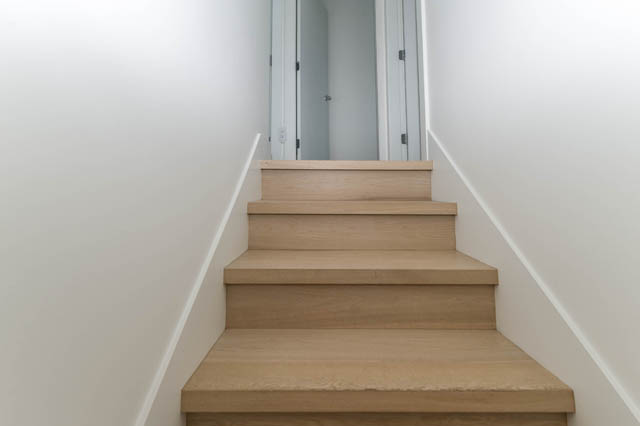 Bright staircase leading to a penthouse with wooden steps and white walls. - 3205 - 928 Richards St, Vancouver Downtown