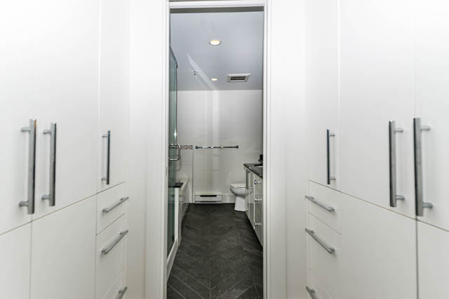 Modern bathroom with sleek white cabinetry and dark gray flooring. - 3205 - 928 Richards St, Vancouver Downtown