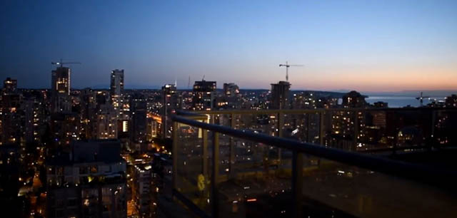 Penthouse with stunning city view at dusk, featuring modern furnishings and expansive windows. - 3205 - 928 Richards St, Vancouver Downtown
