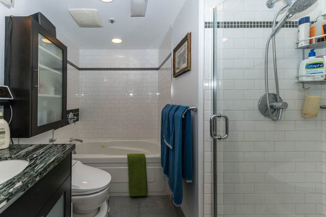 Spacious bathroom with white subway tiles, a bathtub, and a glass shower enclosure. - 409 - 1500 Hornby Street, Vancouver Downtown