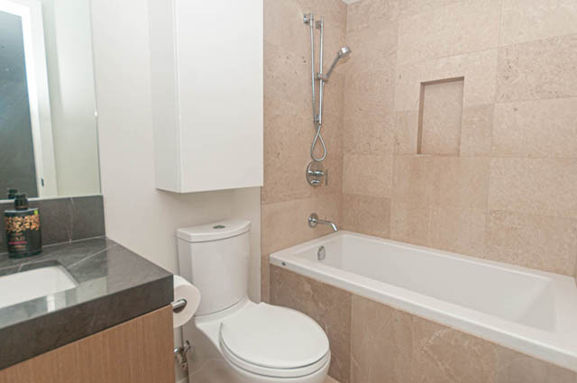 Furnished bathroom with modern sink, toilet, and shower. - 1105 - 125 E 14th St, North Vancouver