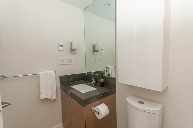 Furnished 1-bedroom bathroom with modern sink and mirror, light-colored walls. - 1105 - 125 E 14th St, North Vancouver