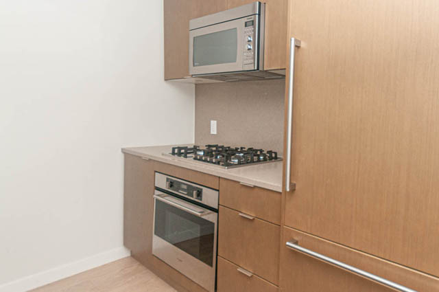 Bright kitchen with light wood cabinets, stainless steel appliances, and a gas stove. - 1105 - 125 E 14th St, North Vancouver
