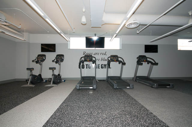 Fitness room with treadmills and exercise bikes, modern flooring. - 1105 - 125 E 14th St, North Vancouver