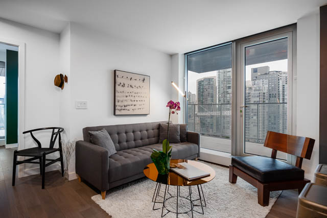 Bright living room with city view, modern furniture, and hardwood floors. - 1901 - 1480 Howe St, Vancouver Downtown