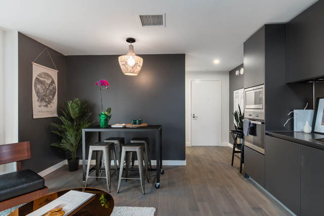 Bright kitchen with dark cabinetry, hardwood floors, and a modern chandelier. - 1901 - 1480 Howe St, Vancouver Downtown