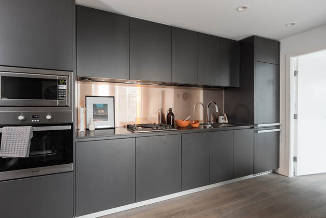 Bright kitchen with dark gray cabinets, stainless steel appliances, and hardwood floors. - 1901 - 1480 Howe St, Vancouver Downtown