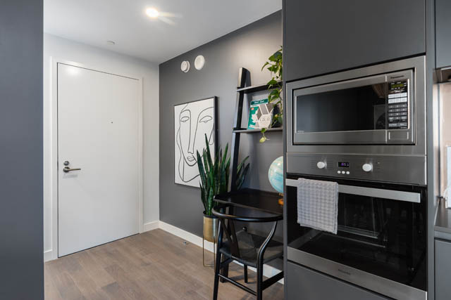 Bright kitchen with stainless steel appliances, hardwood floors, and a modern decor. - 1901 - 1480 Howe St, Vancouver Downtown