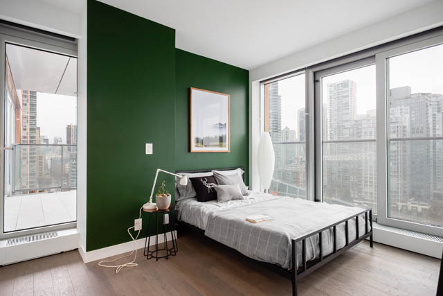 Furnished 1-bedroom condo with hardwood floors, city view, and green accent wall. - 1901 - 1480 Howe St, Vancouver Downtown
