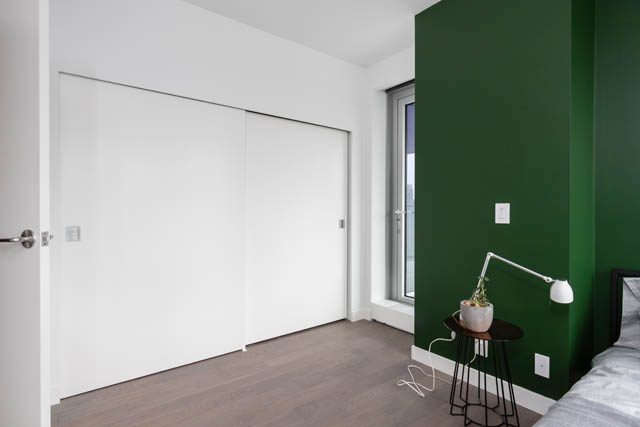 Bright bedroom with green accent wall and modern furnishings. - 1901 - 1480 Howe St, Vancouver Downtown