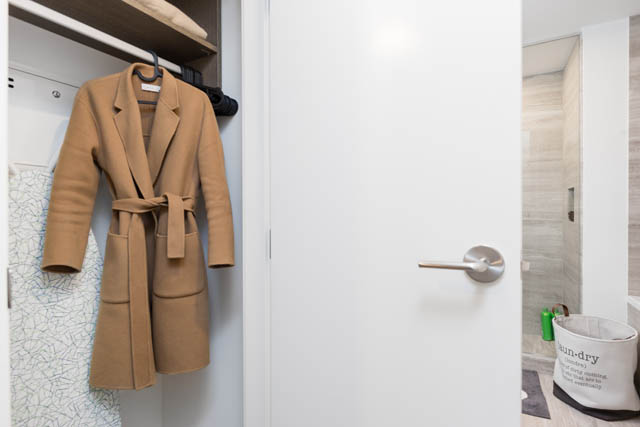 Bright walk-in closet with neatly hung coat and modern door handle. - 1901 - 1480 Howe St, Vancouver Downtown