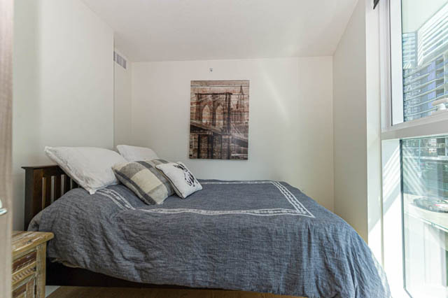 Bright bedroom with large window, city view, and neatly made bed. - 484 - 87 Nelson St, Vancouver Downtown