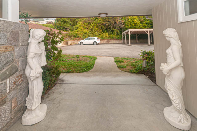 Furnished living room with stone wall and marble statues. - 669 Eyremount Drive, West Vancouver