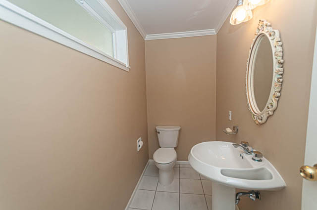 Bright bathroom with beige walls, white sink, and decorative mirror. - 669 Eyremount Drive, West Vancouver