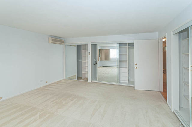 Spacious bedroom with mirrored closet doors and herringbone flooring. - 669 Eyremount Drive, West Vancouver