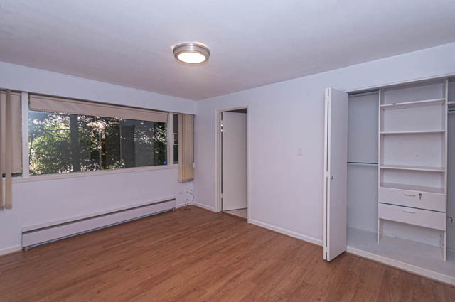 Bright living room with hardwood floors and built-in shelving, natural light from large windows. - 669 Eyremount Drive, West Vancouver