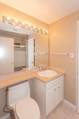 Bright bathroom with beige walls, countertop sink, and vanity lights. - 669 Eyremount Drive, West Vancouver