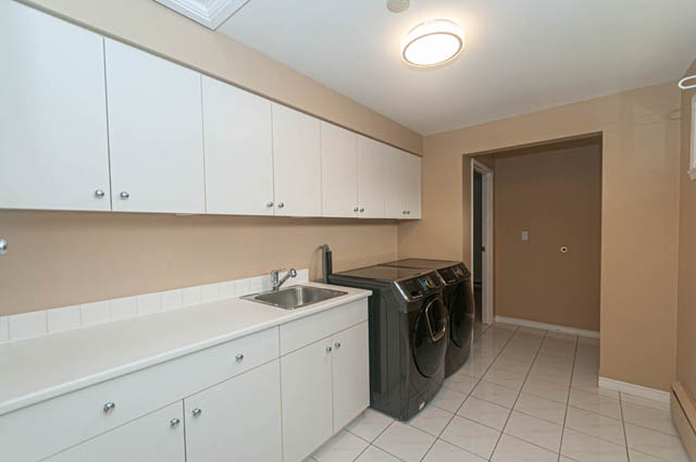 Bright kitchen with white cabinets, granite countertops, and tiled backsplash. - 669 Eyremount Drive, West Vancouver