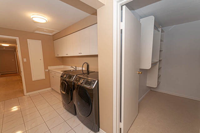 Bright kitchen with white cabinets, stainless steel appliances, and tiled flooring. - 669 Eyremount Drive, West Vancouver