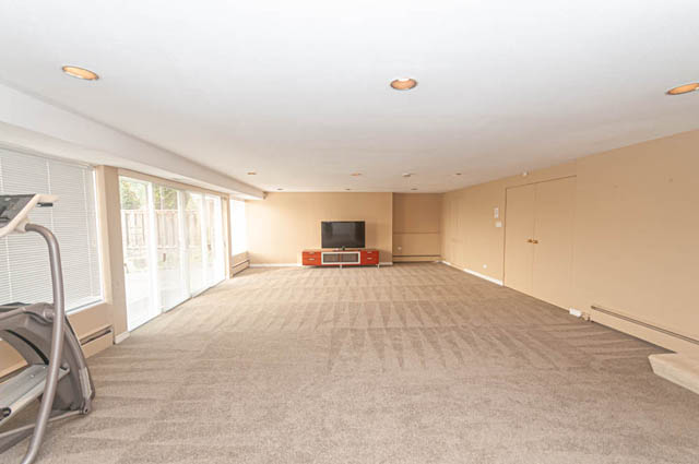 Living room with carpeted floors and sliding glass doors leading to an outdoor area. - 669 Eyremount Drive, West Vancouver